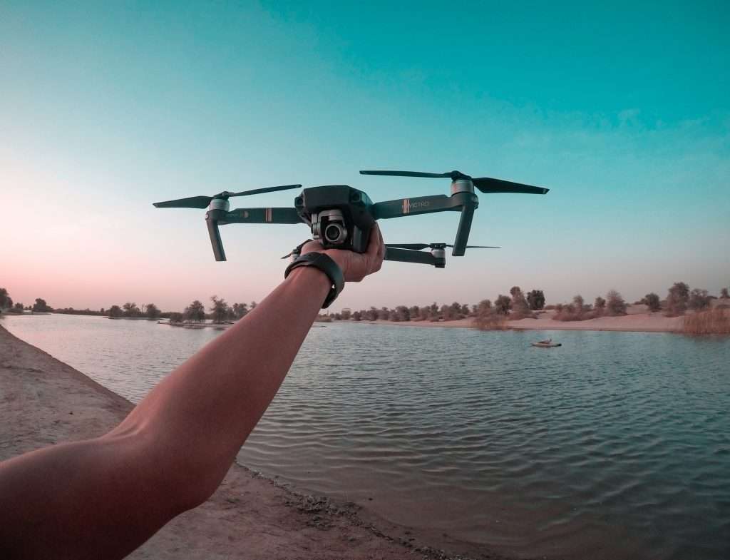 Hand holding drone over water